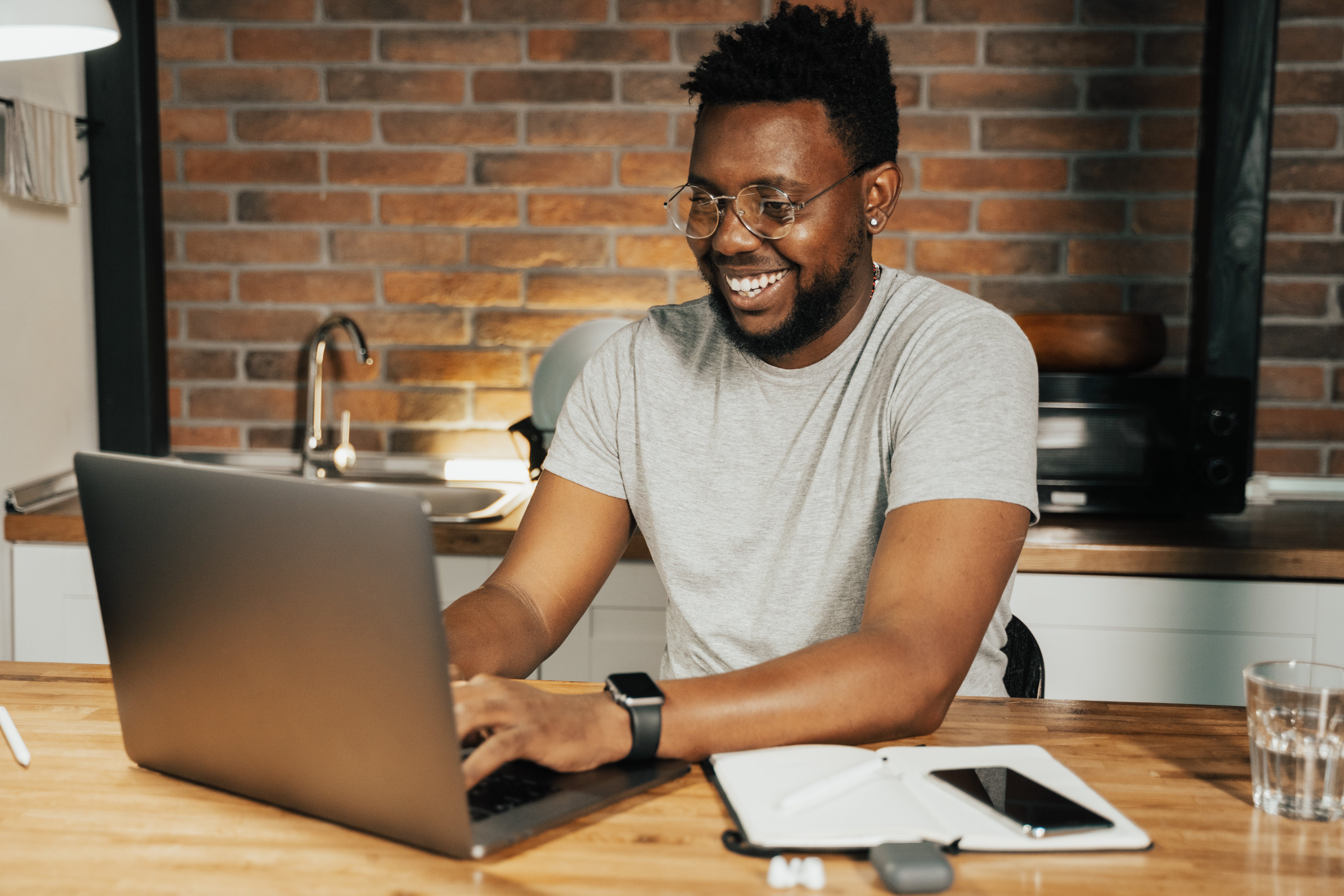 A person smiling while working on a laptop