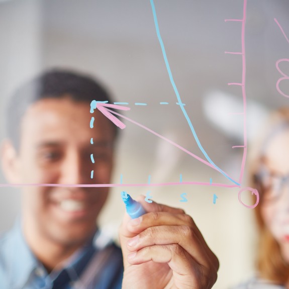 Businessman Sketching Graph On Transparent Board With Highlighter