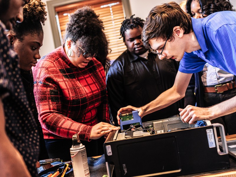 Students working on the motherboard of a computer