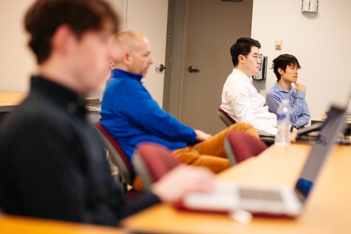 Group of me sitting at a table working on their laptops