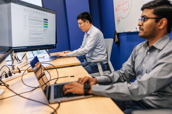 Two men sitting at computers looking at screens