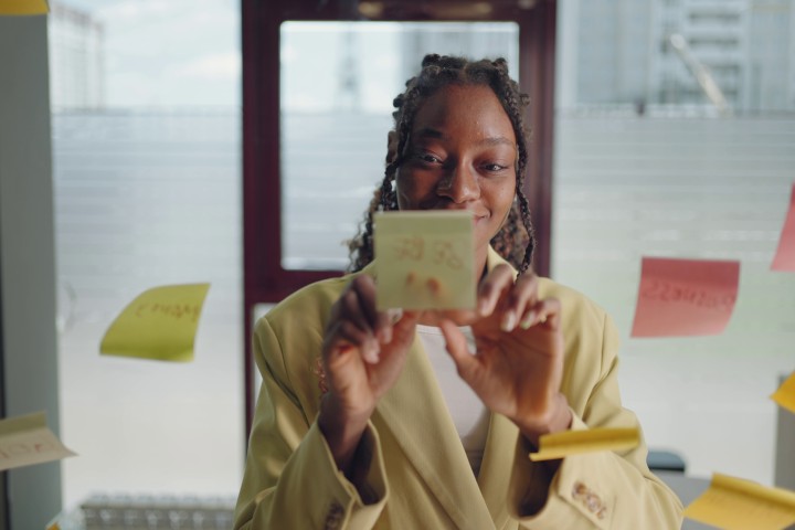 African American writing on a post-it note on the wall