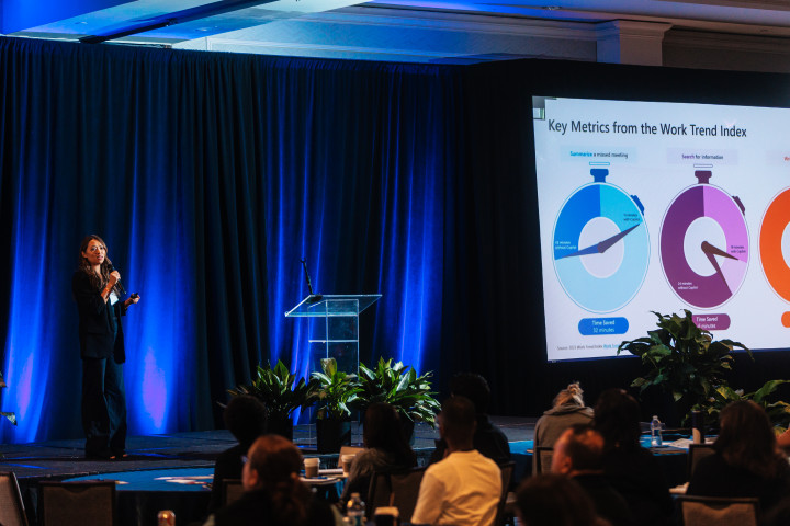A women presenting on a stage talking about technology
