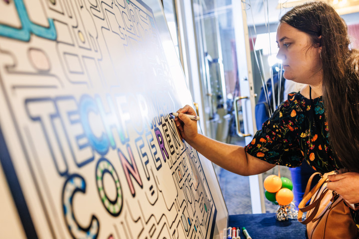 A women drawing on a large posterboard