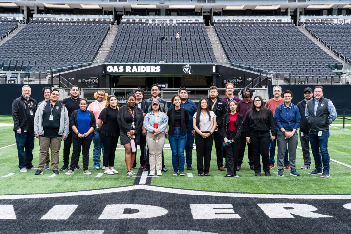 A group of 20 people standing on the field of a stadium